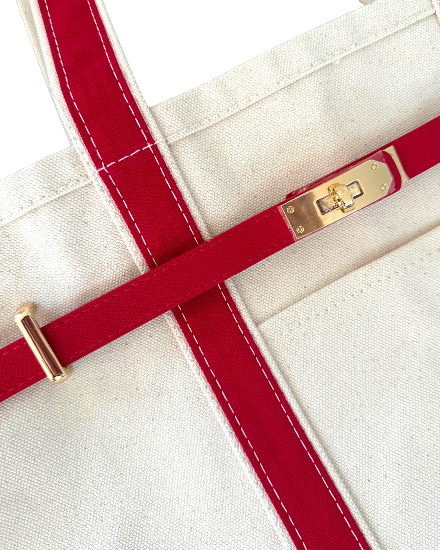 Close-up of a red strap with gold hardware on a white background