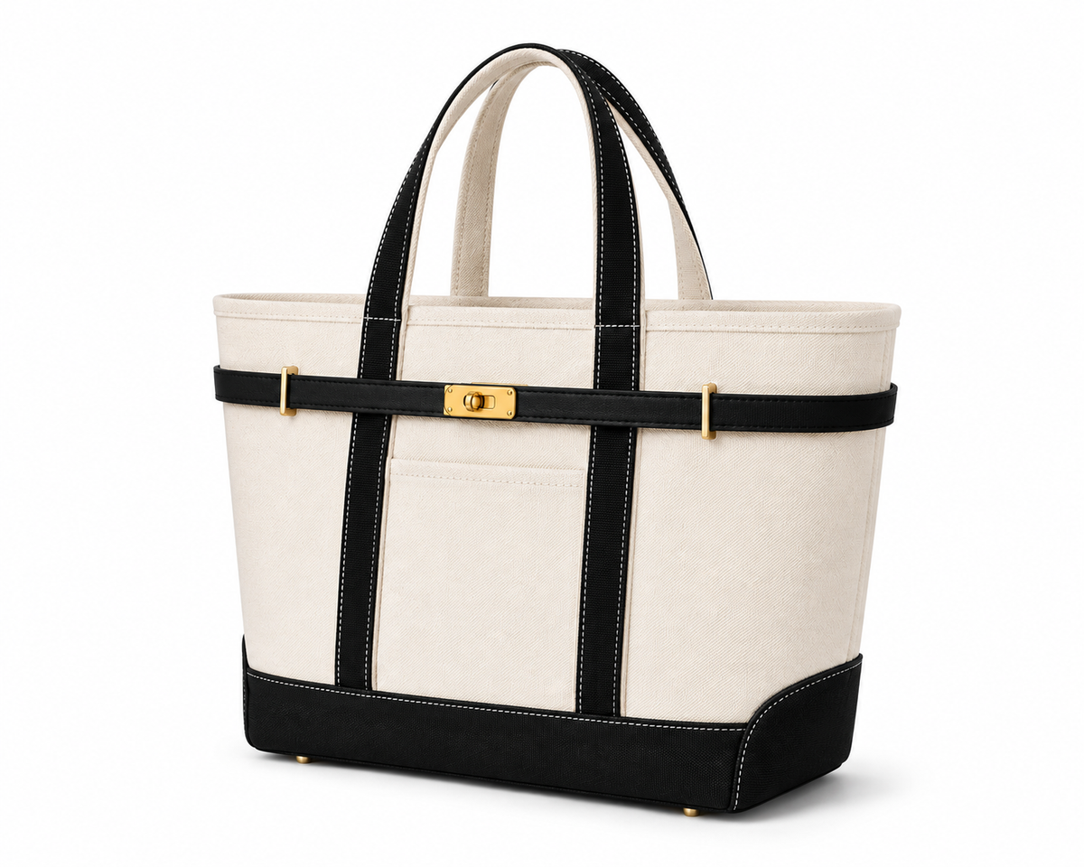 An off-white canvas tote bag with black leather trim, double top handles, a black horizontal strap across the middle, and a gold turn-lock clasp, shown on a white background. Boat Tote Boatkin bag handbag 