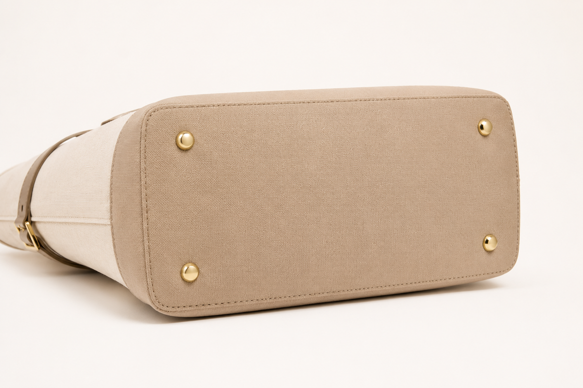 Beige handbag with gold accents on a white background