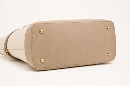 Beige handbag with gold accents on a white background