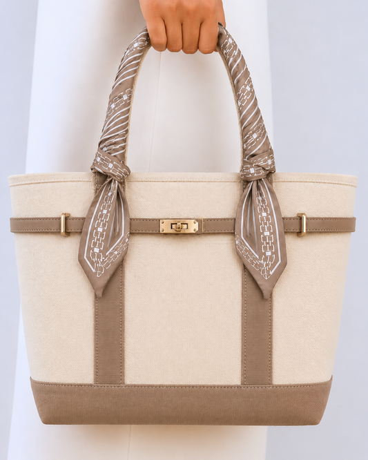 Beige tote bag with decorative handles against a light gray background
